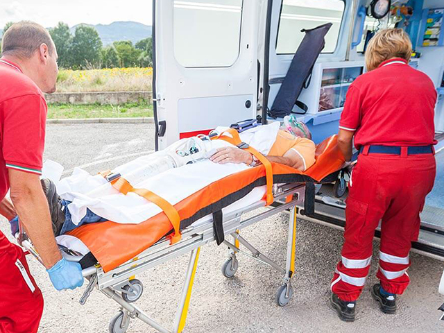 A paramedic pushing a patient towards an ambulance